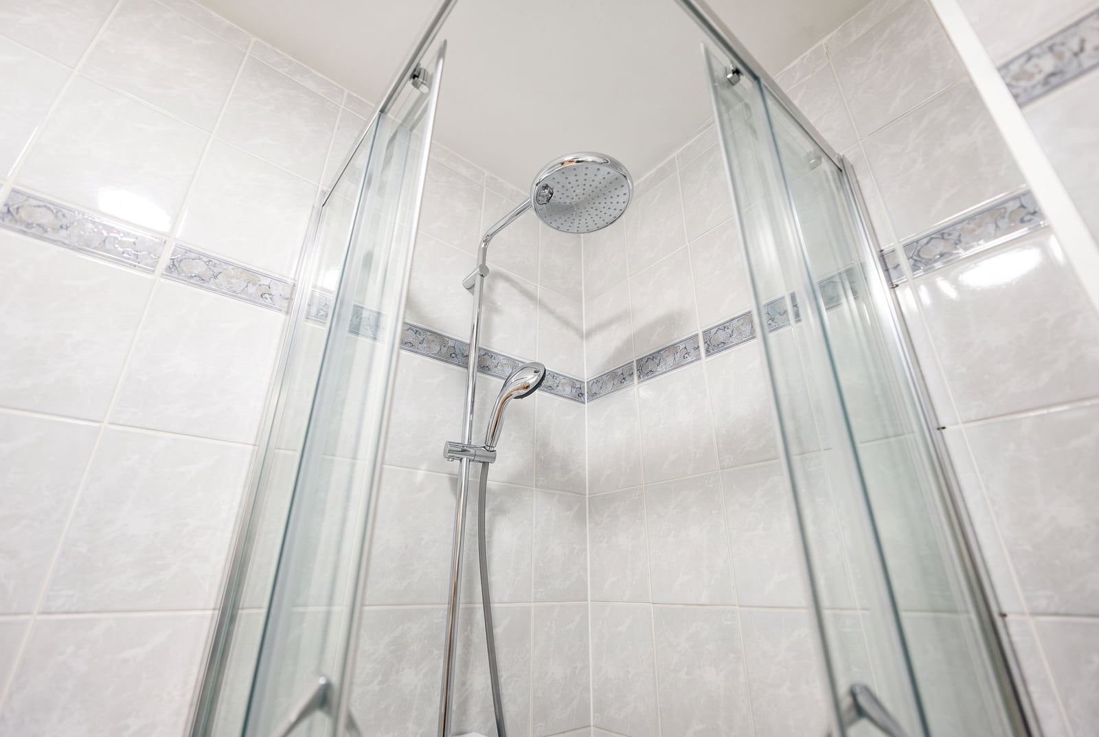 Modern shower cabin with glass doors and a rain shower in an apartment, Sveti Stefan, Montenegro.