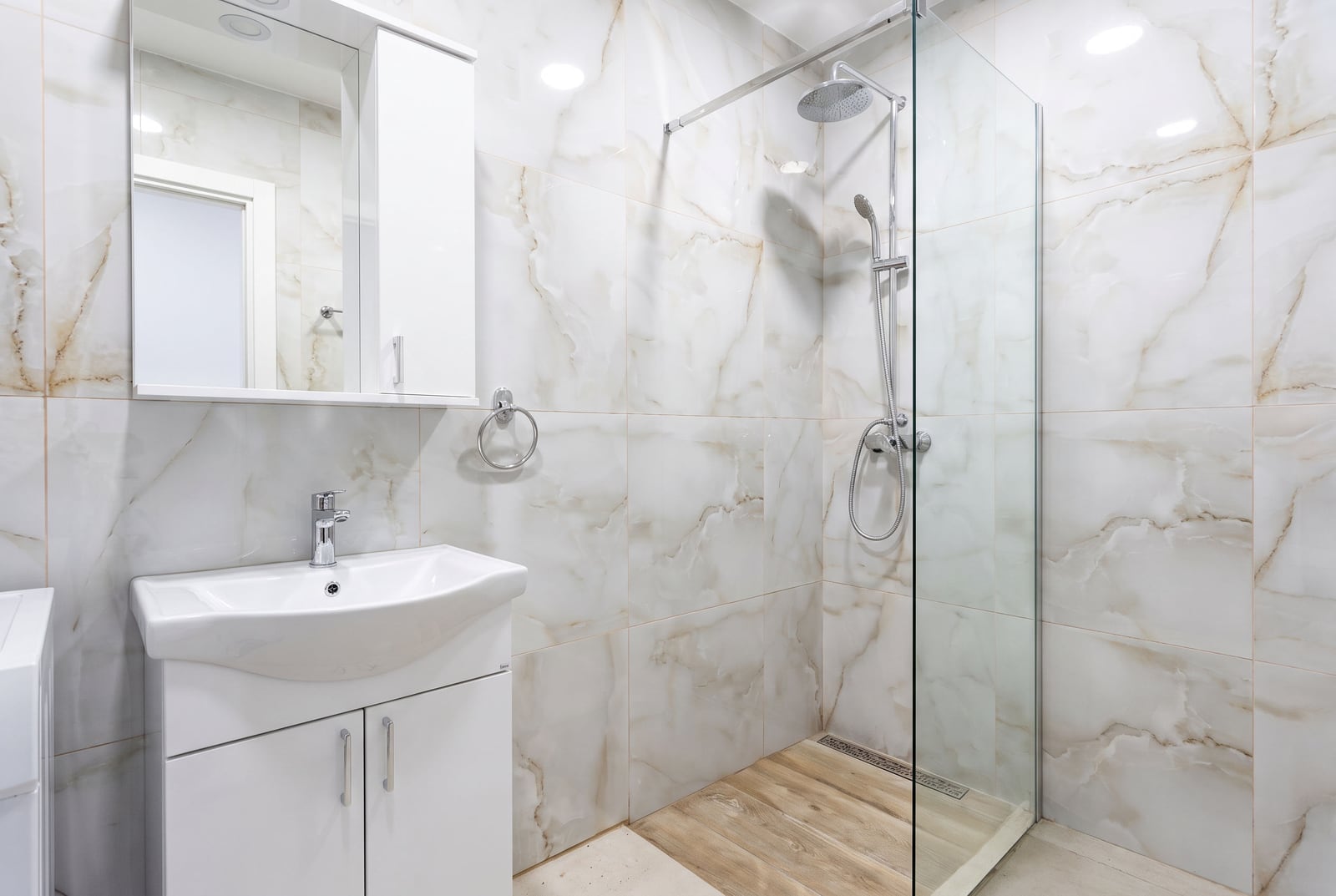 Modern bathroom with a shower enclosure and marble tile in an apartment in Bečići, Montenegro.