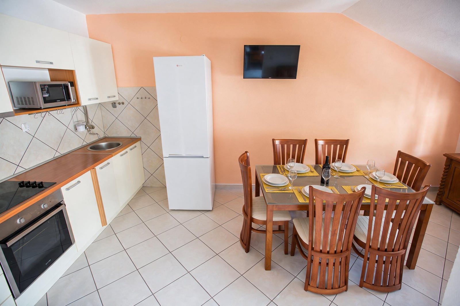 Kitchen and dining area with a wooden table in an apartment in Budva, Montenegro