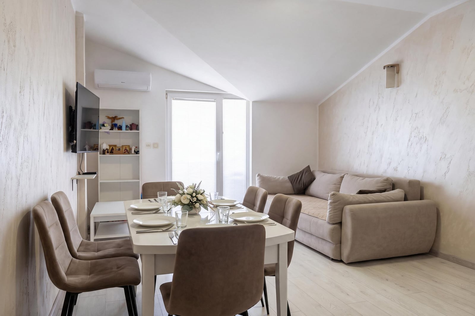 Bright living room with dining area and sofa in an apartment in Igalo, Montenegro