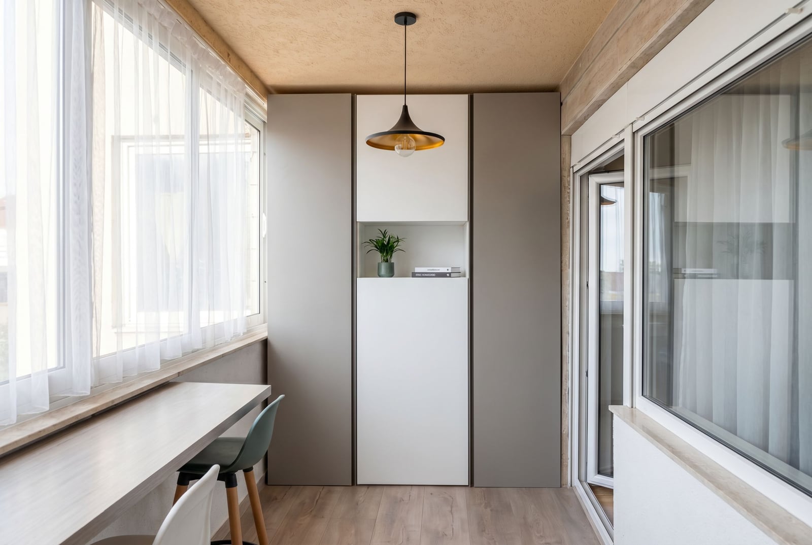 Modern balcony with a workspace and built-in wardrobe in an apartment, Budva, Montenegro. Bright interior with panoramic windows.