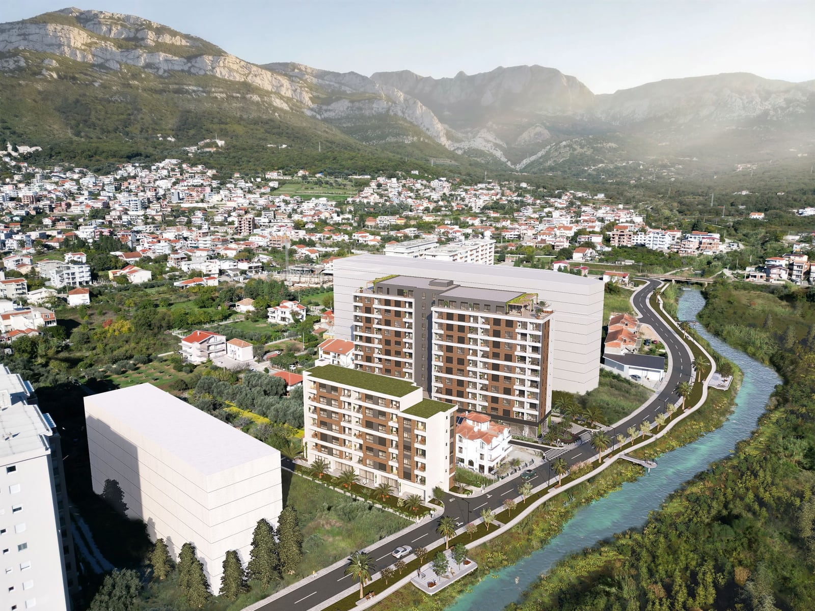 Luftaufnahme eines modernen Wohnkomplexes in der Stadt Bar, Montenegro, nahe einem Fluss und einer Berglandschaft.