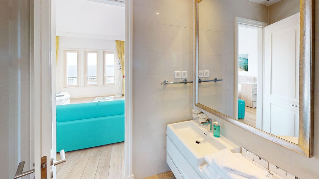 Karadağ, Luštica'daki dairede oturma odasına ve denize bakan modern banyo.