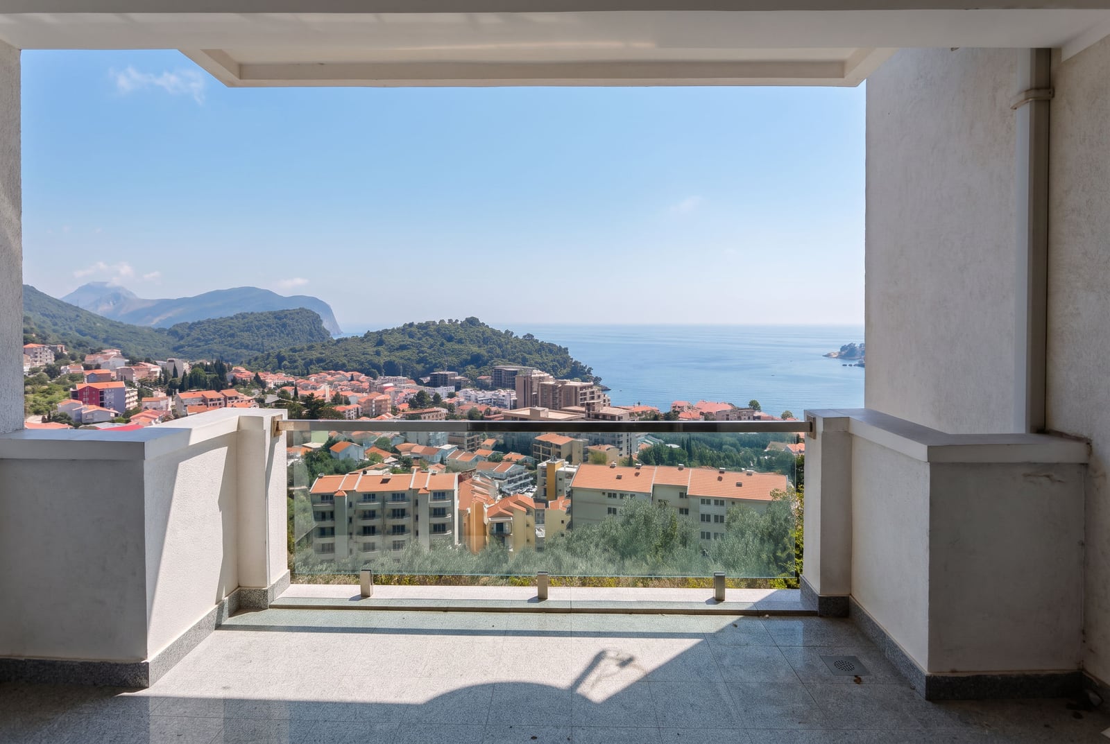 Panoramic view from the apartment balcony of the sea, mountains, and the town of Petrovac in Montenegro.