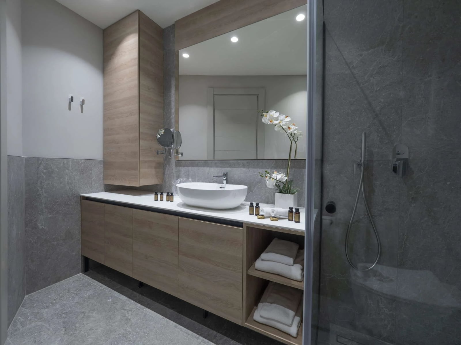 Moderna kupatilo sa tušem i drvenim nameštajem u apartmanima u Bečićima, Crna Gora