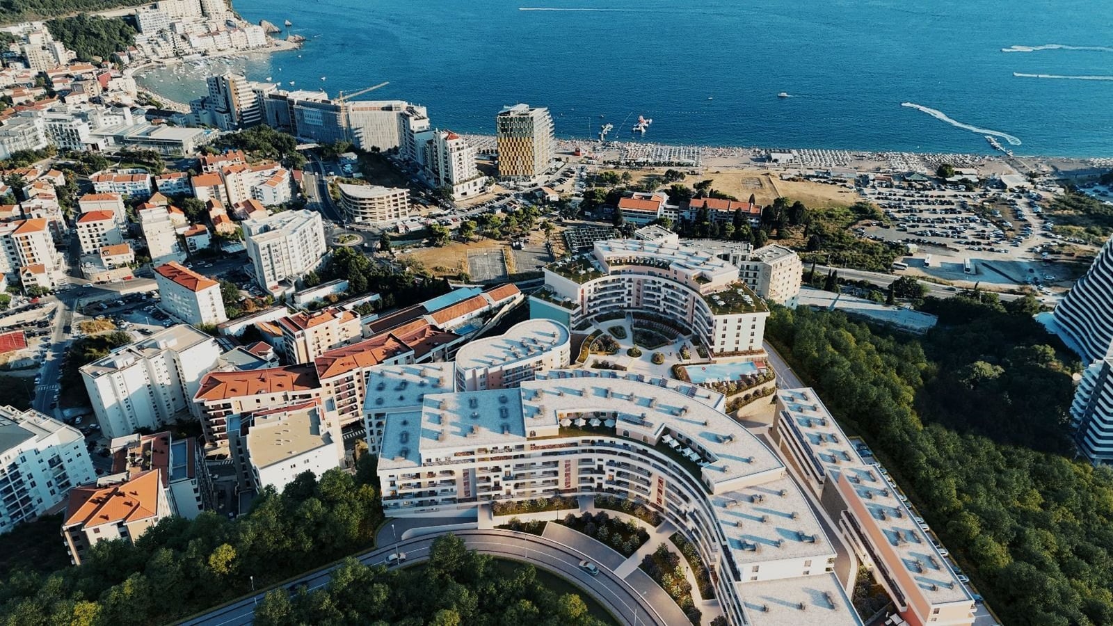 Karadağ, Bečići’deki konut kompleksinin havadan görünümü: modern mimari, havuz ve Adriyatik Denizi manzarası.