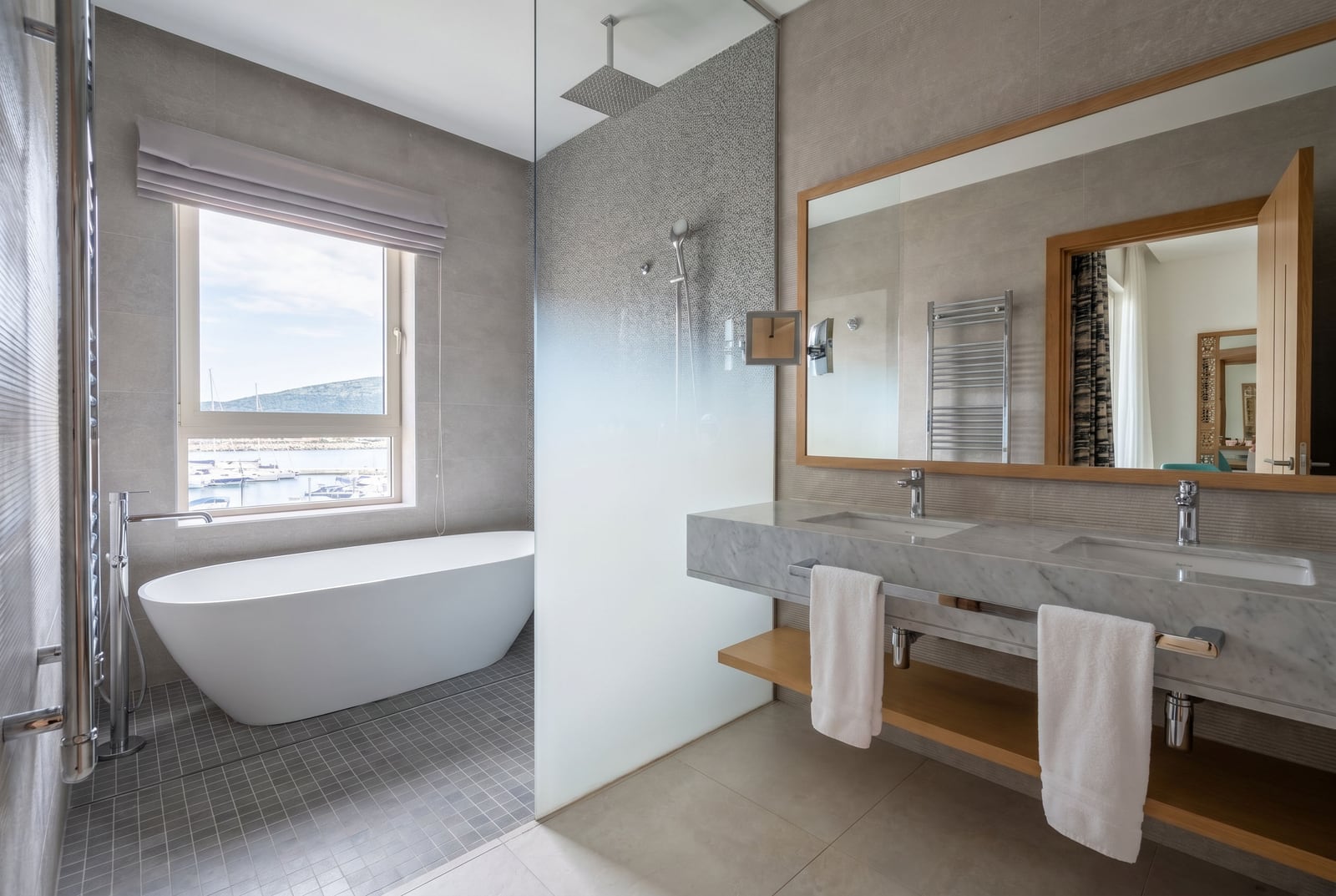Modernes Badezimmer in Luštica, Montenegro: freistehende Badewanne, Blick auf den Yachthafen, Marmorwaschtisch.
